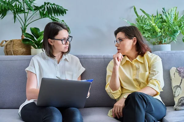 Middle-aged woman in individual therapy session in psychologist office. Counselor talking, taking notes with mature patient. Psychology, mental health, counseling, social work, psychotherapy concept