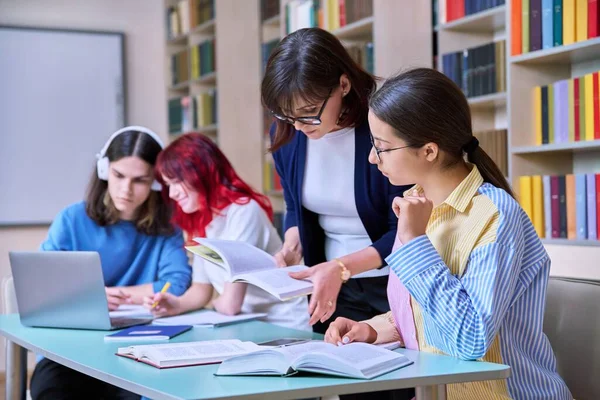 Grupp Tonårselever Studerar Skolbibliotekets Klassrum Tonårstjej Och Kvinnlig Lärarmentor Hjälper — Stockfoto