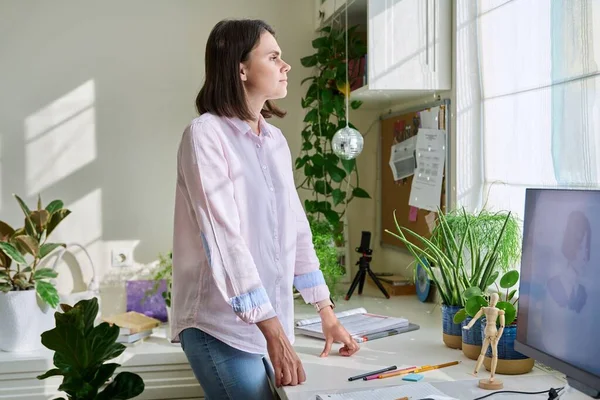 Young Confident Woman Looking Out Window While Standing Workplace Home — Stockfoto