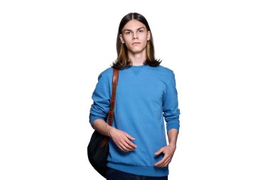 Beyaz izole edilmiş arka planda sırt çantalı yakışıklı bir gencin portresi. Genç erkek üniversite öğrencisi stüdyoda poz verirken kameraya bakıyor. Eğitim, üniversite, halk, gençlik kavramı