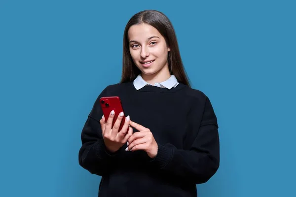 Student Teenager Smartphone His Hands Blue Color Studio Background Attractive — Foto de Stock