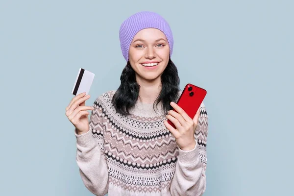 Beautiful Young Woman Sweater Cap Holding Credit Card Smartphone Looking — стоковое фото