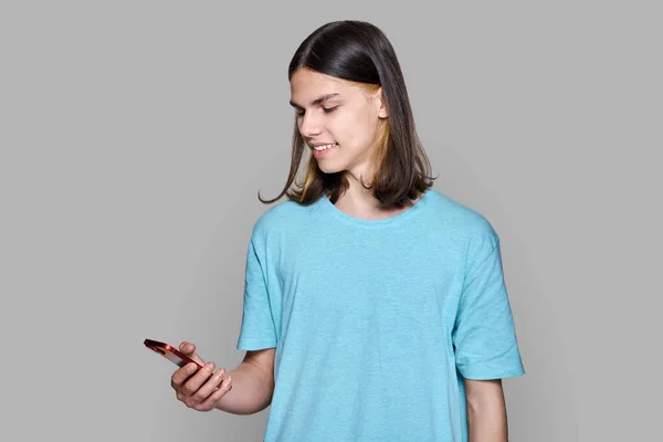 Teenager Guy Smartphone His Hands Gray Colored Background Smiling Happy — Stockfoto