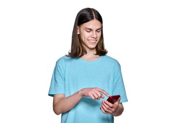 Teenager guy with smartphone in his hands on white isolated background. Smiling happy teenage male looking at phone screen