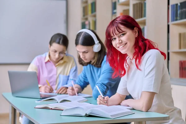 Smiling Teenage Female Student Looking Camera While Sitting Desk Classmates — Stock fotografie