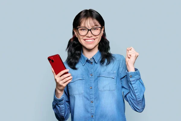 Happy Teenage Girl Smartphone Making Winner Gesture Emotional Female Teenager —  Fotos de Stock