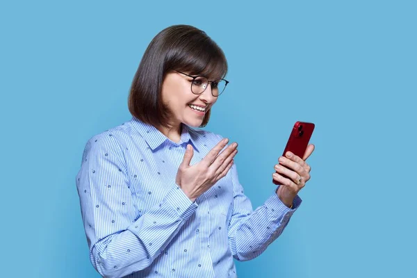 Middle Aged Business Woman Using Smartphone Video Call Blue Background — 스톡 사진