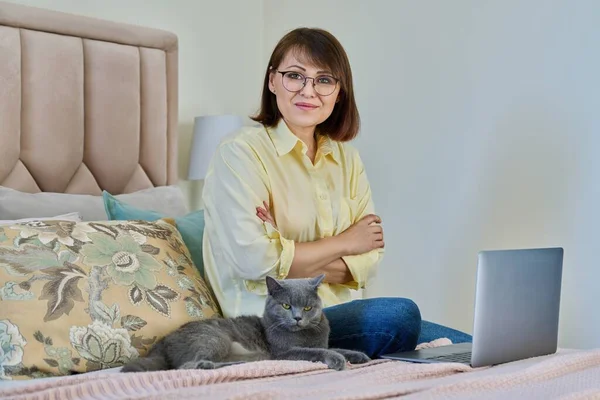 Portrait Middle Aged Woman Pet Cat Sitting Bed Home Laptop — Stockfoto