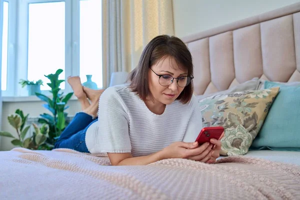 Middle Aged Relaxed Woman Lying Bed Home Using Smartphone Mobile — 스톡 사진