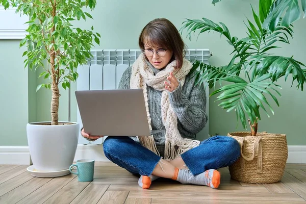 Middle Aged Female Warm Clothes Warming Heating Radiator Using Laptop — Fotografia de Stock