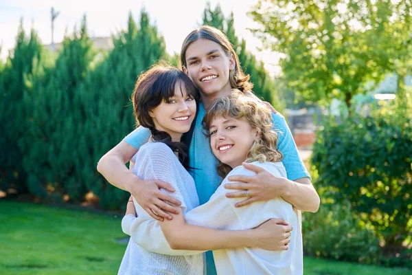 Portret Trójki Szczęśliwych Nastolatków Przytulających Się Patrząc Kamerę Facet Dwie — Zdjęcie stockowe