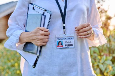 Bir eğitim merkezinde çalışan bir kadın için yakın plan bir rozet. Pano sahibi kadın, öğretmen, akıl hocası psikolog sosyal hizmet danışmanı danışman hocası, profesyonel konsept.