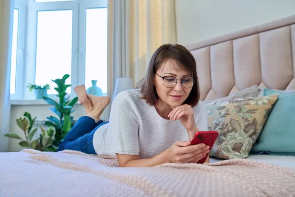 Middle Aged Relaxed Woman Lying Bed Home Using Smartphone Mobile —  Fotos de Stock