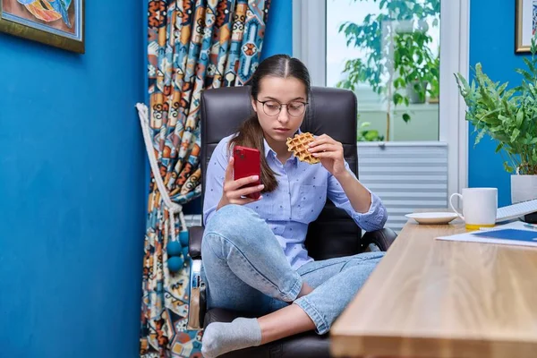 Ragazza Adolescente Seduta Una Poltrona Vicino Computer Guardando Nello Smartphone — Foto Stock