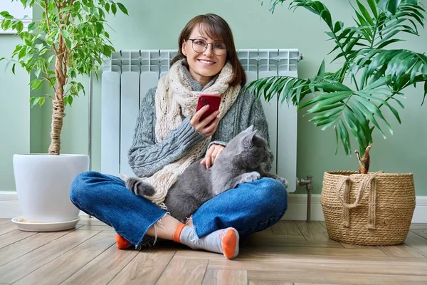 Middle Aged Woman Resting Home Warm Clothes Using Smartphone Warming — Stockfoto