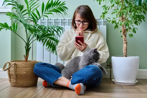 Middle Aged Woman Resting Home Warm Clothes Using Smartphone Warming — Stockfoto