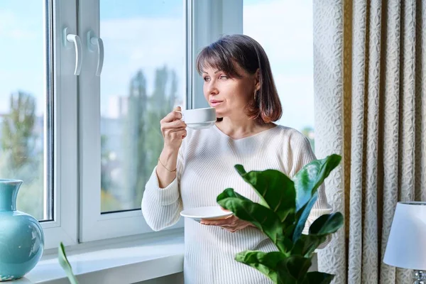 Vrouw Van Middelbare Leeftijd Thuis Bij Het Raam Met Een — Stockfoto