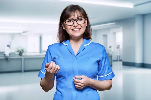 医院内中年女护士的画像 积极的医生微笑着看着接待室里的摄像机 工作人员 保健服务 新概念 — 图库照片