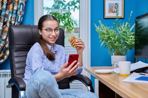 Dospívající Dívka Sedí Křesle Počítače Dívá Smartphonu Vafle Mladá Žena — Stock fotografie