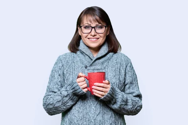 穿着毛衣的快乐的成熟女人的冬季肖像 背景浅浅的杯子 微笑的女性看着相机 生活方式 新年圣诞观念 — 图库照片