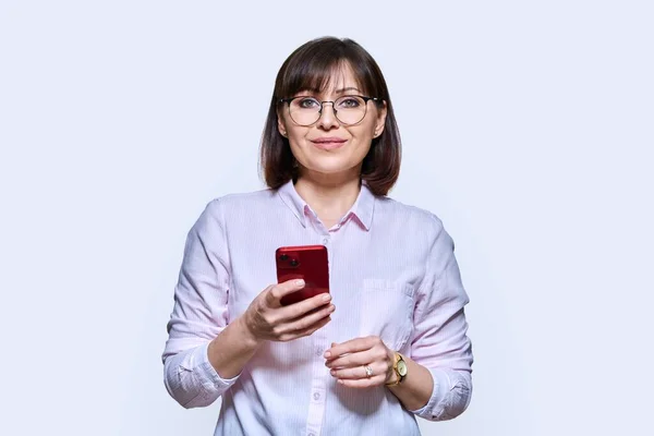 Μεσήλικη Επιχειρηματίας Smartphone Στα Χέρια Χαμογελαστή Γυναίκα Κοιτάζοντας Κάμερα Λευκό — Φωτογραφία Αρχείου