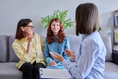 Çocuk psikologu seansı, anne ergen kızı ve davranış terapisti ofiste birlikte. Profesyonel yardım, ruh sağlığı, davranış düzeltmesi, danışmanlık, psikoloji terapisi, çocuk ailesi