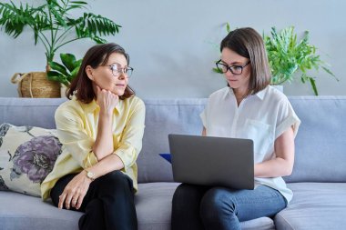 Terapi seansı, psikolog muayenehanesinde danışmanlık yapan olgun bir kadın not alan genç bir kadın terapist. Psikoloji, psikoterapi, profesyonel yardım, 40 'lı yaşlarda orta yaşlı insanların akıl sağlığı.