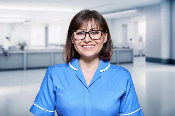 医院内中年女护士的画像 积极的医生微笑着看着接待室里的摄像机 工作人员 保健服务 新概念 — 图库照片
