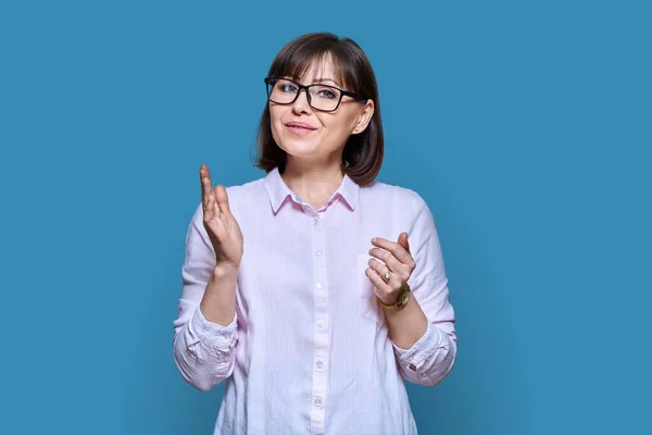 Talking Gesturing Woman Looking Camera Blue Color Studio Background Middle — Stock Photo, Image