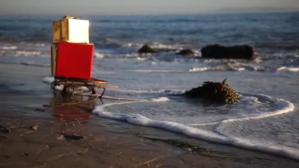 Cadouri de Crăciun pe o sanie pe plaja din Malibu, Los Angeles, SUA — Videoclip de stoc