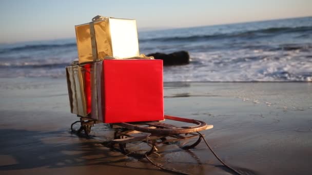Regalos de Navidad en un trineo en la playa de Malibú, Los Ángeles, Estados Unidos — Vídeo de stock