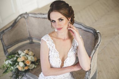 Güzel gelin gelinlik beyaz fotoğraf Studio poz. Ayna. Kanepe. Buket. Kapıyı. Avize.