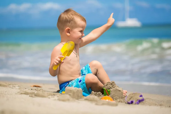 Söt baby pojke leker med stranden leksaker på tropisk strand. — Stockfoto