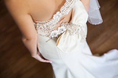 Nedime gelinliğin arkasında yay düğümü yapıyor..