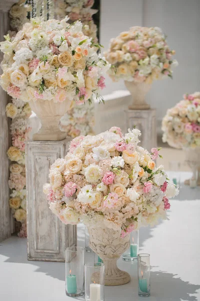 El ramo hermoso de las rosas en el florero sobre el fondo del arco de boda. Hermosa puesta en marcha para la ceremonia de boda — Foto de Stock