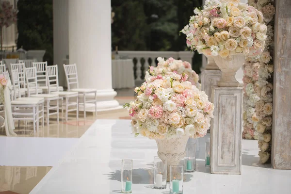 El ramo hermoso de las rosas en el florero sobre el fondo del arco de boda. Hermosa puesta en marcha para la ceremonia de boda — Foto de Stock