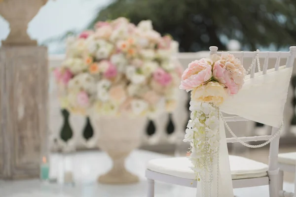 Hochzeitsdekoration Blumen auf Stühlen. Hochzeitsanmeldung, weiße Stühle für die Hochzeit dekoriert. Detail der Hochzeitsvorbereitung — Stockfoto