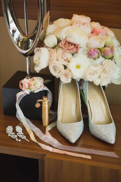 Detalhes do casamento. Acessórios da noiva: sapatos, um buquê de flores, jóias — Fotografia de Stock
