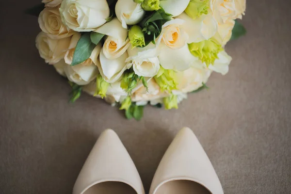 Os acessórios de casamento das noivas: sapatos e um luxuoso buquê de flores — Fotografia de Stock