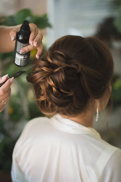 El estilista maestro hace que el peinado de la boda de la novia usando fijación de laca en aerosol . — Foto de Stock
