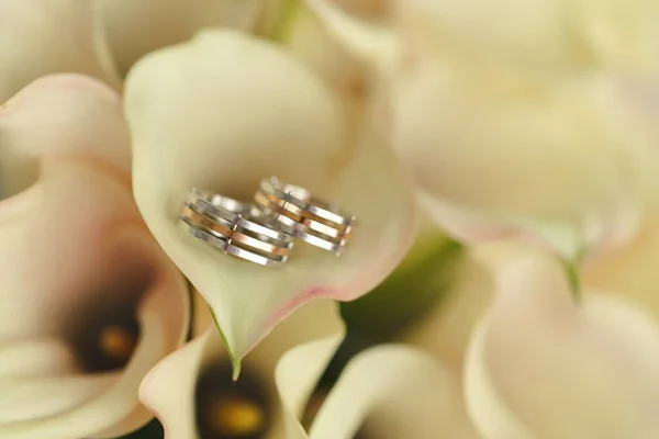 Ślubne złote obrączki z bukietem lilii kalla — Zdjęcie stockowe