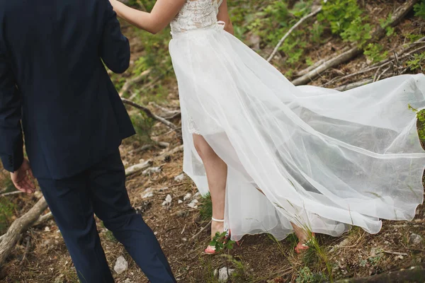 Pengantin pria dan wanita berjalan bersama-sama memegang tangan mereka — Stok Foto