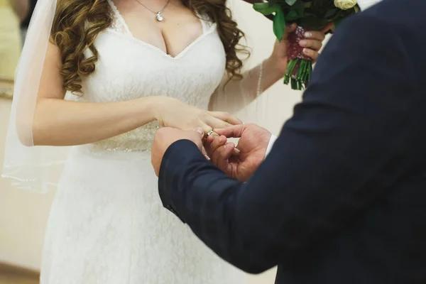 Gli sposi si scambiano anelli, lo sposo mette l'anello sulla mano delle spose nell'ufficio del registro matrimoniale.. — Foto Stock