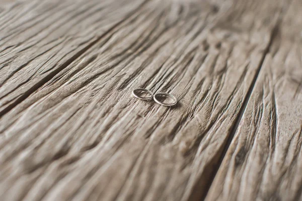 Макросъемка золотых обручальных колец на фактуре дерева — стоковое фото