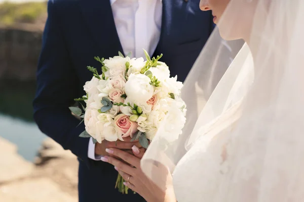 Buquê de casamento delicado de flores brancas, rosa e em pó nas mãos da noiva — Fotografia de Stock