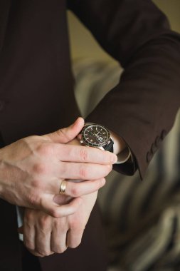 Damadın elleri saat ile yakın plan..