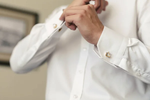 Los hombres se ponen una camisa y abrochan gemelos en la mañana del día de la boda — Foto de Stock