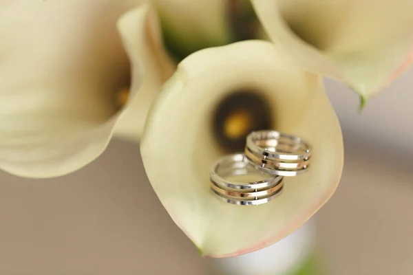 Wedding gold rings with a bouquet of calla lilies — Stock Photo, Image