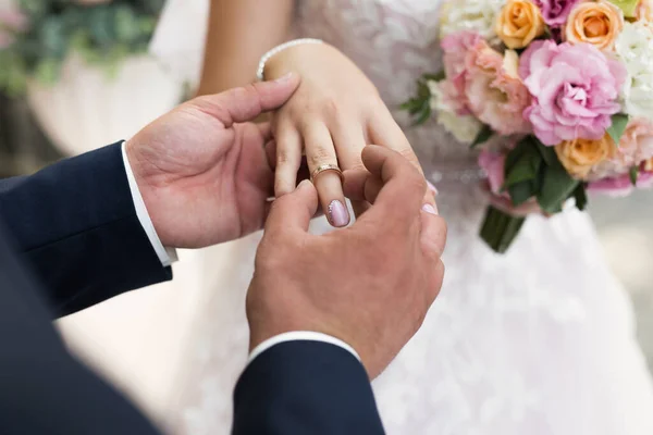 O noivo coloca o anel no dedo da noiva em close-up. — Fotografia de Stock