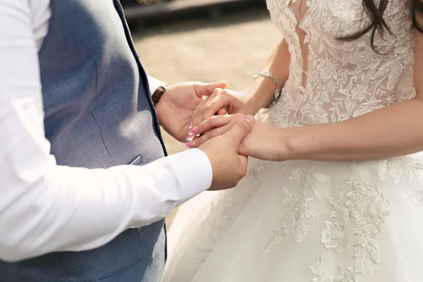 Невеста и жених держатся за руки во время свадебной церемонии . — стоковое фото